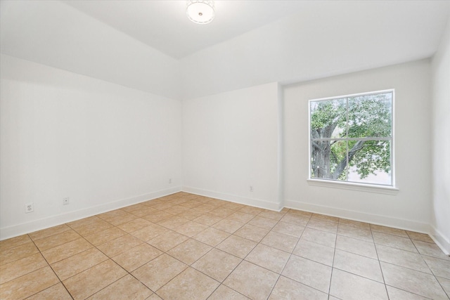 spare room with light tile patterned floors and baseboards