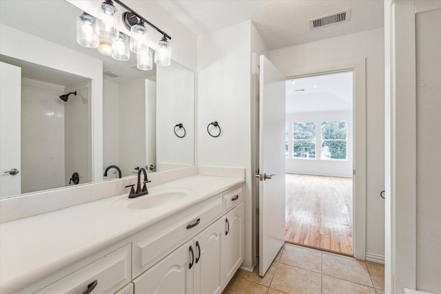 full bath featuring tile patterned flooring, visible vents, and vanity