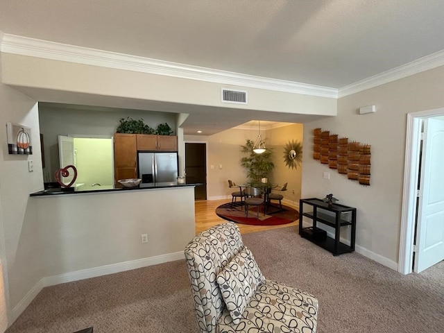 living room with light carpet, ornamental molding, visible vents, and baseboards