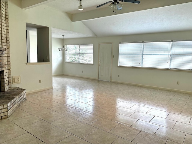 unfurnished living room with a textured ceiling, a brick fireplace, baseboards, and vaulted ceiling with beams