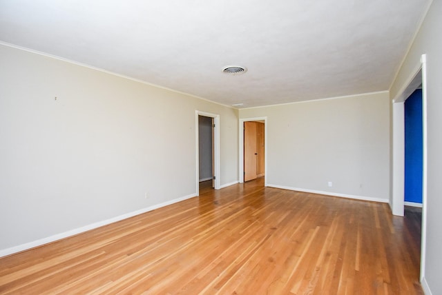 unfurnished room with crown molding, wood finished floors, and baseboards