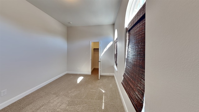 carpeted empty room featuring baseboards