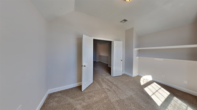 unfurnished bedroom with carpet floors, lofted ceiling, visible vents, and baseboards