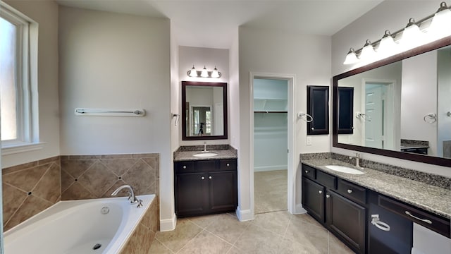 full bath with a garden tub, two vanities, a sink, and tile patterned floors