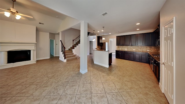 kitchen with open floor plan, a fireplace, backsplash, and visible vents