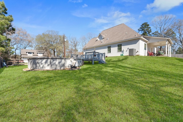 back of house with an outdoor pool, central AC, a lawn, and a deck