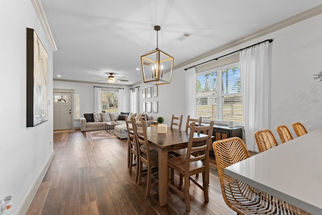 dining space featuring dark wood-style floors, crown molding, visible vents, an inviting chandelier, and baseboards