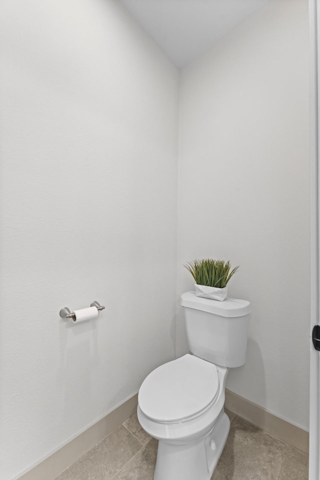 bathroom with baseboards and toilet