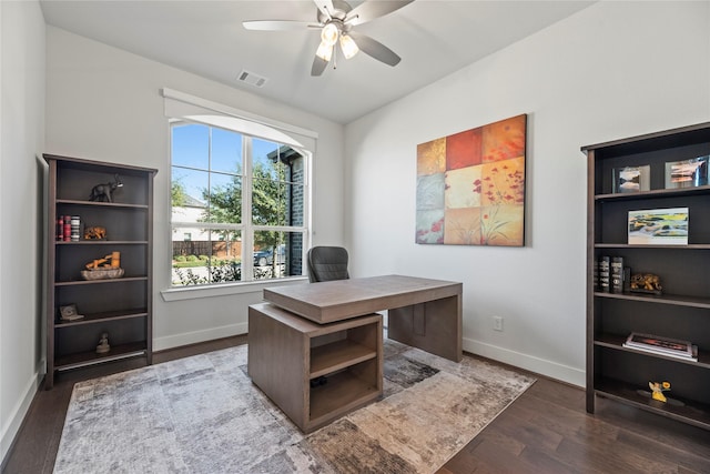 office with dark wood-type flooring, visible vents, baseboards, and a ceiling fan