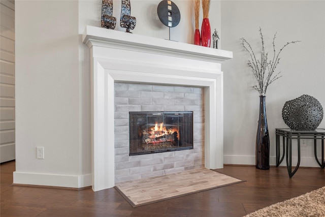 room details with a tiled fireplace, wood finished floors, and baseboards