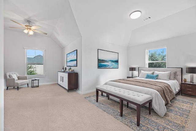 bedroom with light colored carpet, lofted ceiling, visible vents, and multiple windows