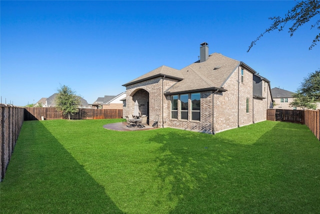 back of house featuring a patio area, a fenced backyard, a lawn, and brick siding