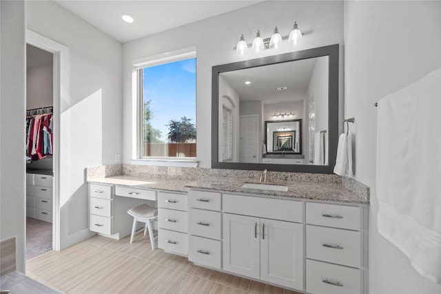 bathroom featuring a walk in closet and vanity