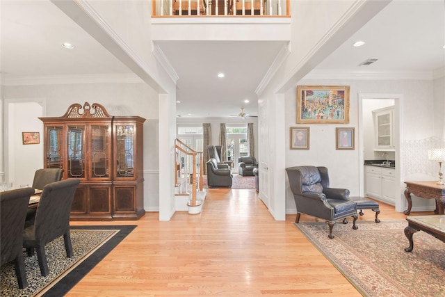 foyer featuring light wood finished floors, visible vents, stairs, crown molding, and recessed lighting