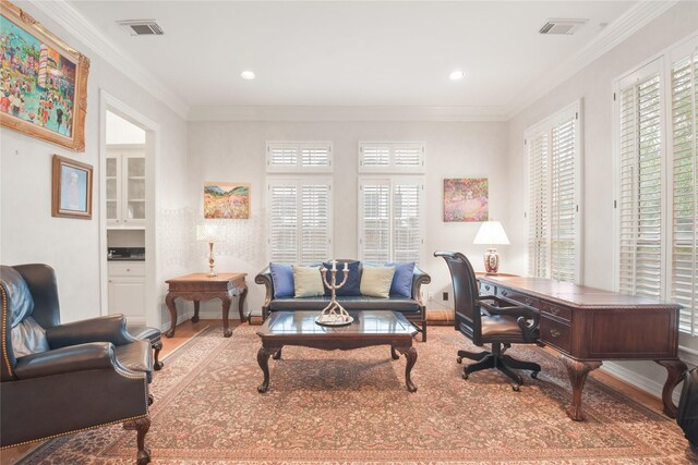 office space with visible vents, crown molding, and baseboards