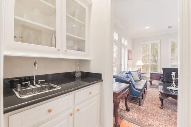 bar with visible vents, ornamental molding, a sink, and recessed lighting