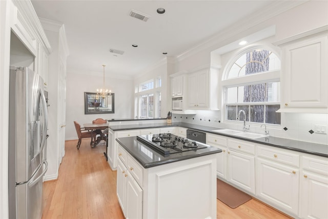 kitchen featuring dark countertops, stainless steel refrigerator with ice dispenser, a kitchen island, and white cabinets