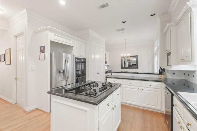 kitchen featuring stainless steel appliances, dark countertops, white cabinets, and visible vents