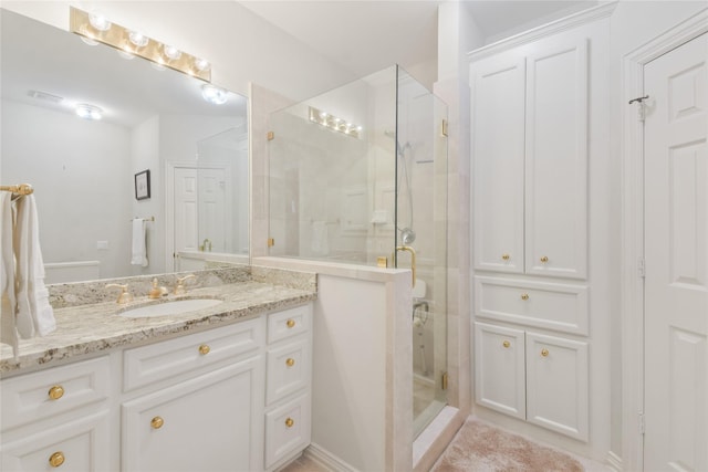 bathroom featuring a stall shower, vanity, and visible vents