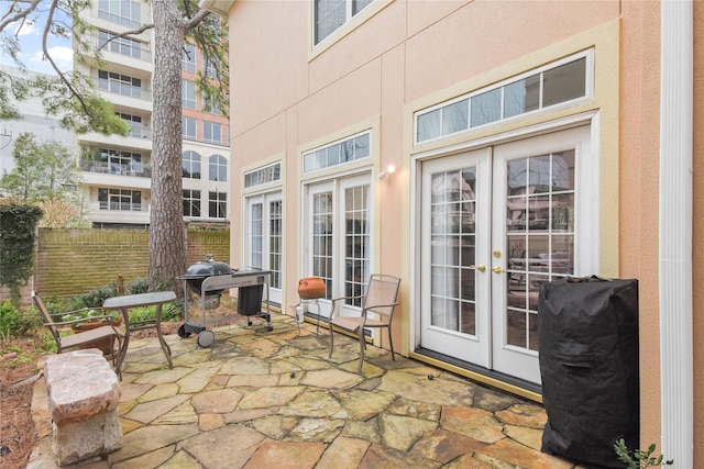 view of patio with french doors, fence, and area for grilling