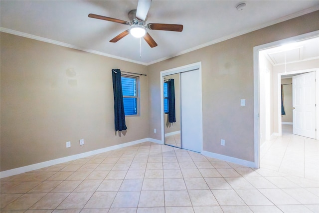 unfurnished bedroom with light tile patterned floors, baseboards, attic access, and crown molding