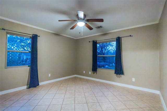 empty room featuring baseboards, visible vents, and crown molding