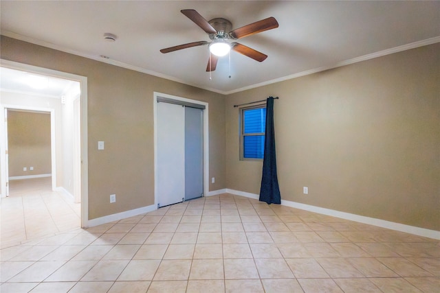 unfurnished bedroom with a closet, crown molding, baseboards, and light tile patterned floors