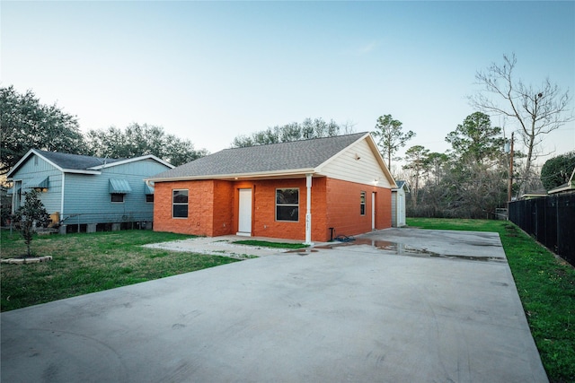 view of front of property featuring a front yard, brick siding, and fence