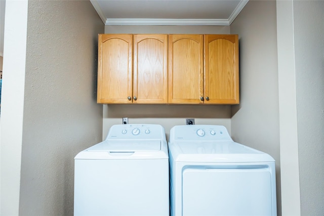 clothes washing area with washing machine and dryer, cabinet space, and crown molding