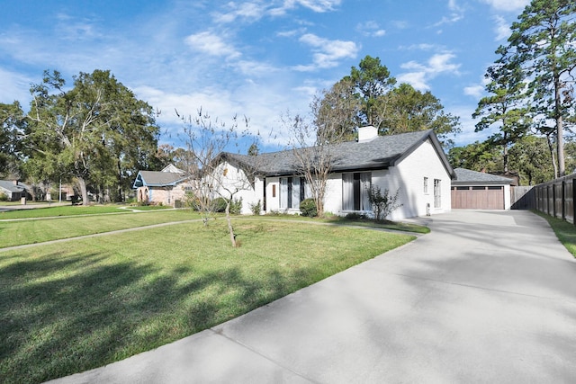 view of front of property featuring a garage, concrete driveway, a chimney, fence, and a front yard