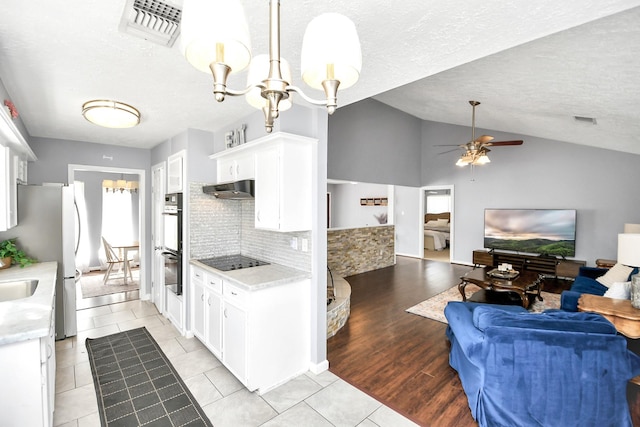 kitchen featuring under cabinet range hood, visible vents, and white cabinets