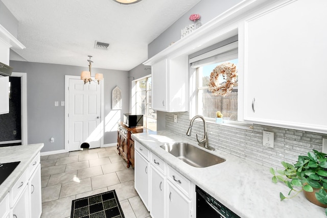 kitchen featuring visible vents, hanging light fixtures, backsplash, white cabinetry, and a sink