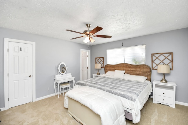 carpeted bedroom featuring ceiling fan, a textured ceiling, and baseboards