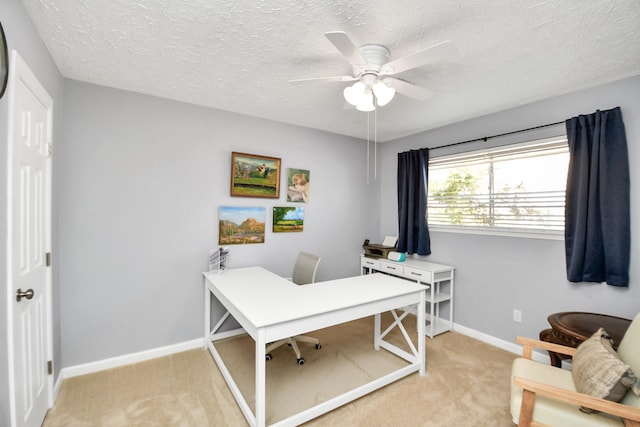 office with ceiling fan, a textured ceiling, baseboards, and light colored carpet