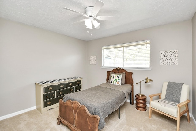 carpeted bedroom featuring a textured ceiling, a ceiling fan, and baseboards