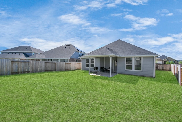 rear view of house featuring a patio area, a fenced backyard, a shingled roof, and a yard