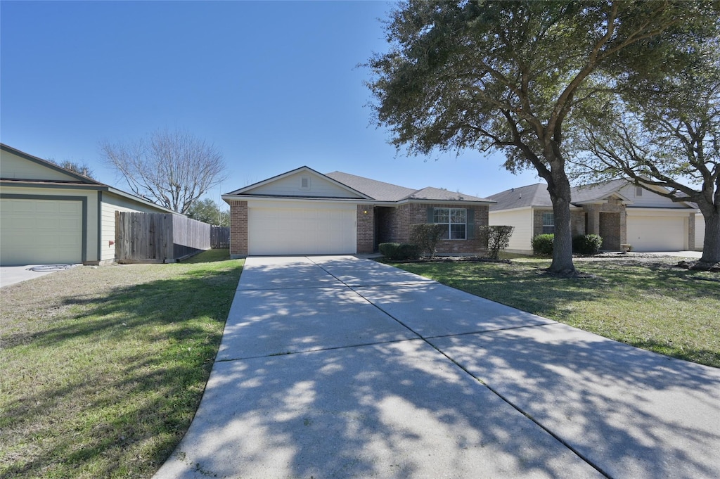 28914 Trinity River Dr, Spring, TX 77386 - ranch-style home featuring an attached garage, brick siding, fence, concrete driveway, and a front yard