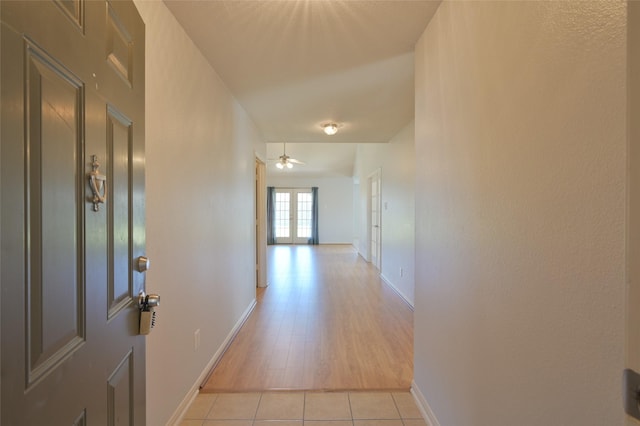 hall with light tile patterned floors and baseboards