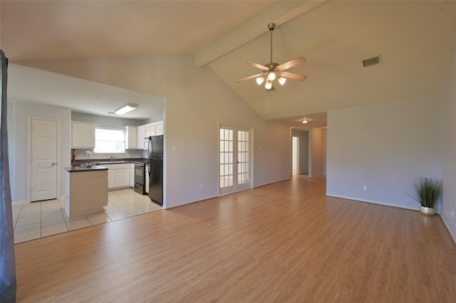 unfurnished living room with visible vents, a ceiling fan, light wood-style flooring, beam ceiling, and a sink