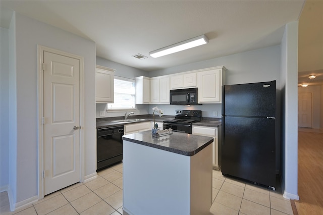 kitchen featuring light tile patterned floors, a sink, white cabinetry, black appliances, and dark countertops