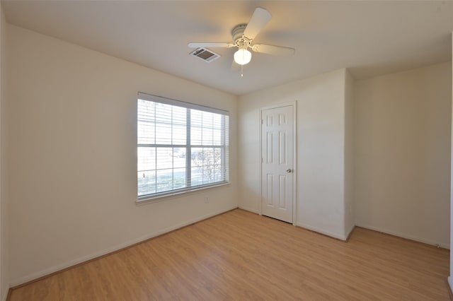 unfurnished bedroom featuring a closet, visible vents, light wood-style flooring, ceiling fan, and baseboards