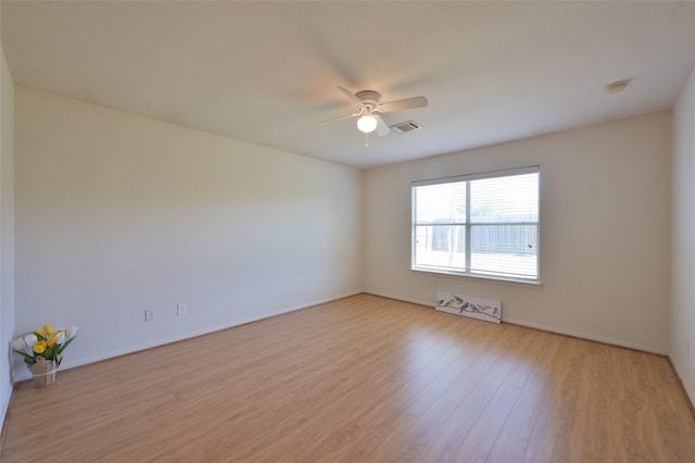 empty room with light wood-style floors, visible vents, and a ceiling fan