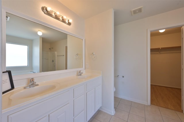 bathroom with visible vents, a sink, a shower stall, and tile patterned floors