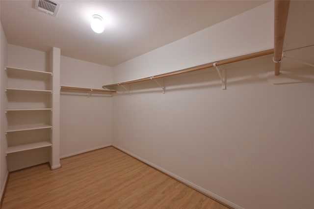 walk in closet with light wood-type flooring and visible vents