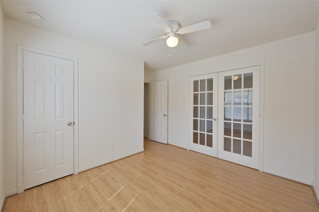 spare room with light wood finished floors, french doors, and a ceiling fan