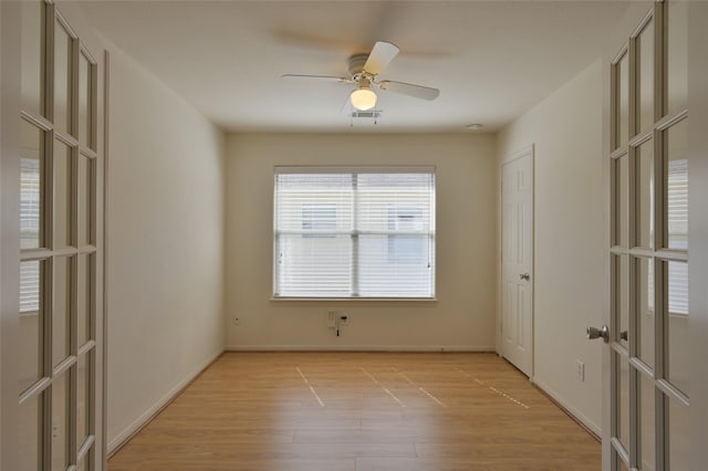 spare room featuring baseboards, visible vents, a ceiling fan, french doors, and light wood-style floors