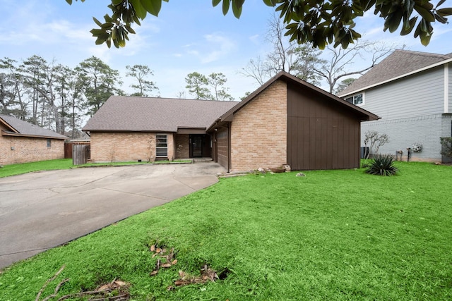 mid-century modern home with concrete driveway, brick siding, a front lawn, and roof with shingles