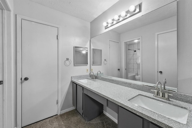 bathroom with a sink, a textured ceiling, and double vanity