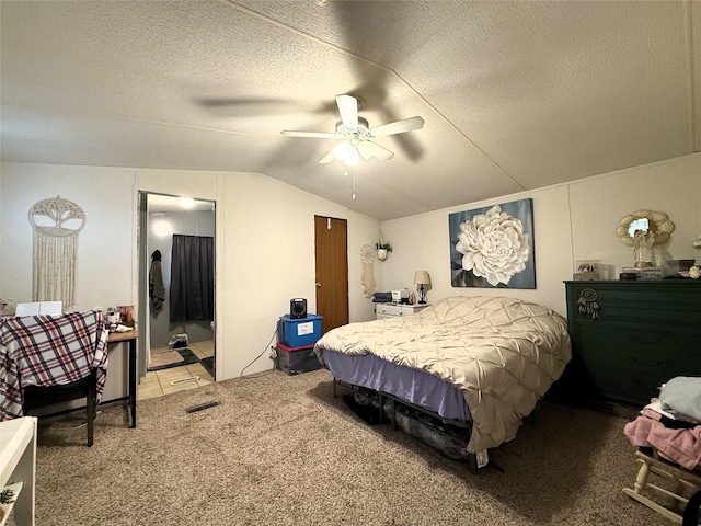 bedroom with a ceiling fan, light carpet, connected bathroom, vaulted ceiling, and a textured ceiling