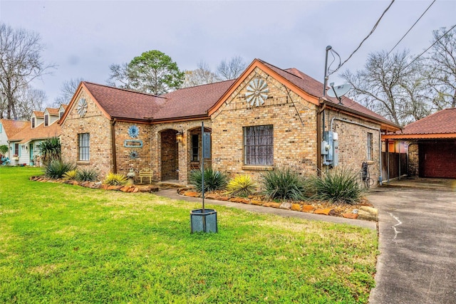 view of front of house with driveway, brick siding, a front yard, and a shingled roof